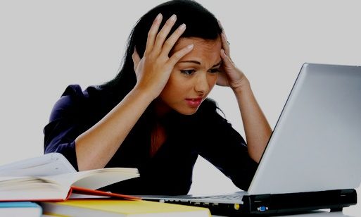 a young woman writing on a laptop computer