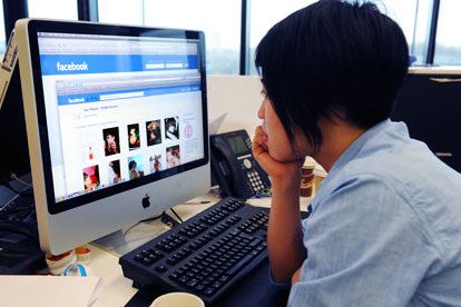 woman looking at Facebook in office